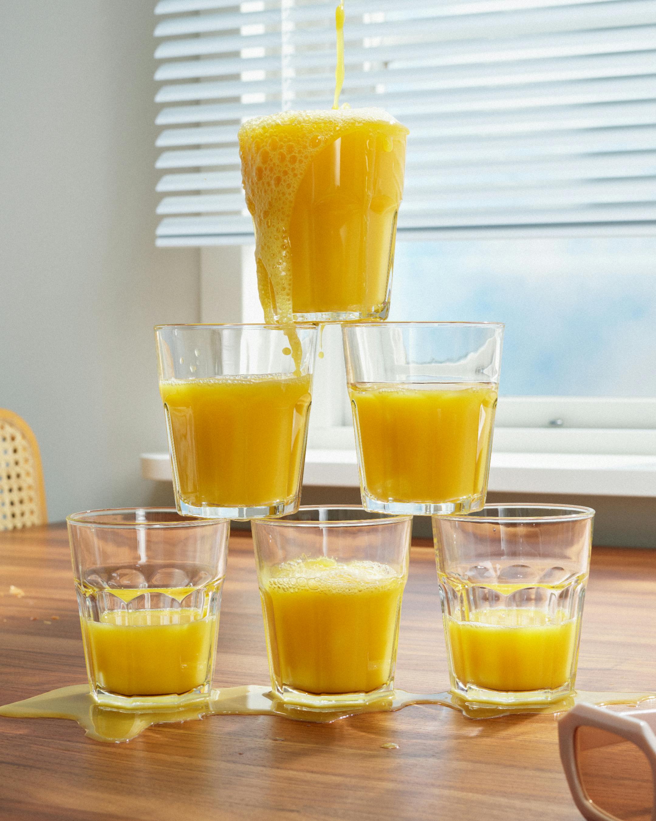 A still life of orange juice glasses